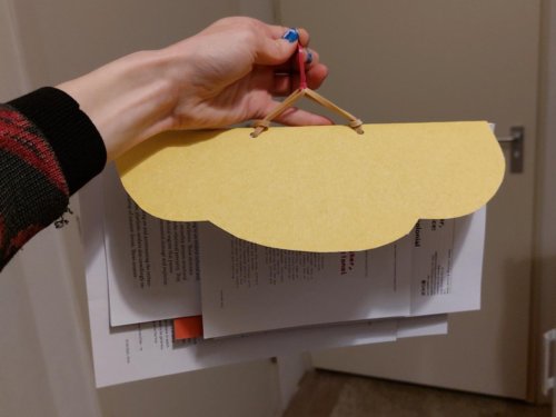 Hand holds cloud-shaped binder hanging from elastic bands