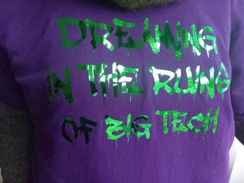 T-Shirt close-up, with a slogan reading: Dreaming in the Ruins of Big Tech"