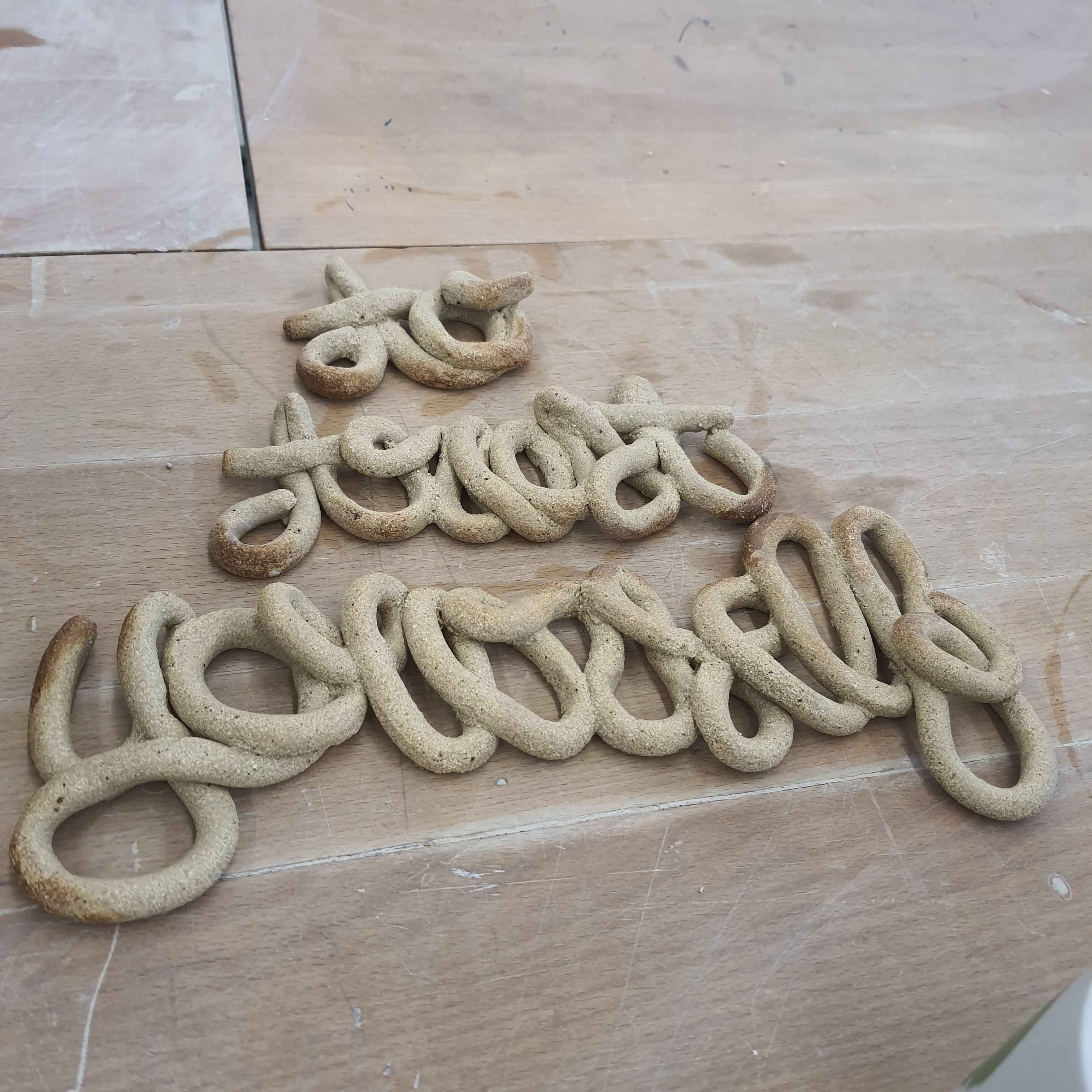 A coiled encrypted text, burnt ceramics, looking like baked bread.