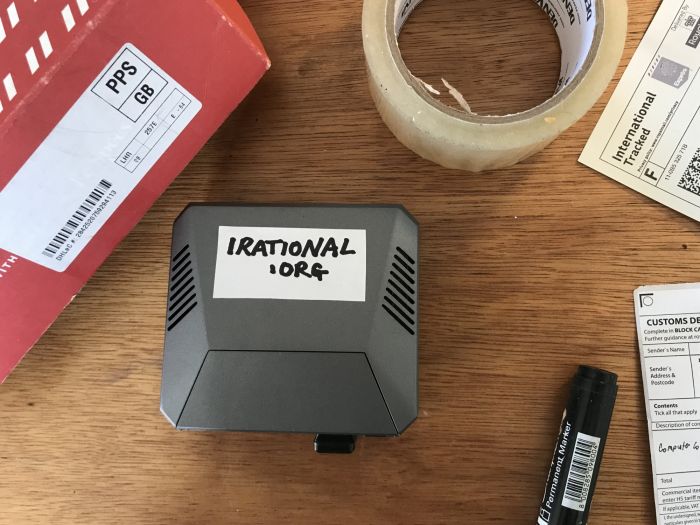 A black tech-box marked "irational.org", on a table alongside packing materials